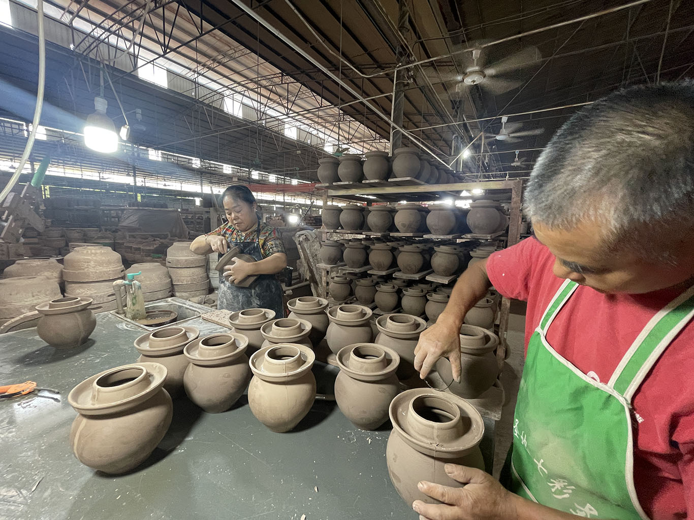 Craftsmen manually polish clay kimchi crocks
