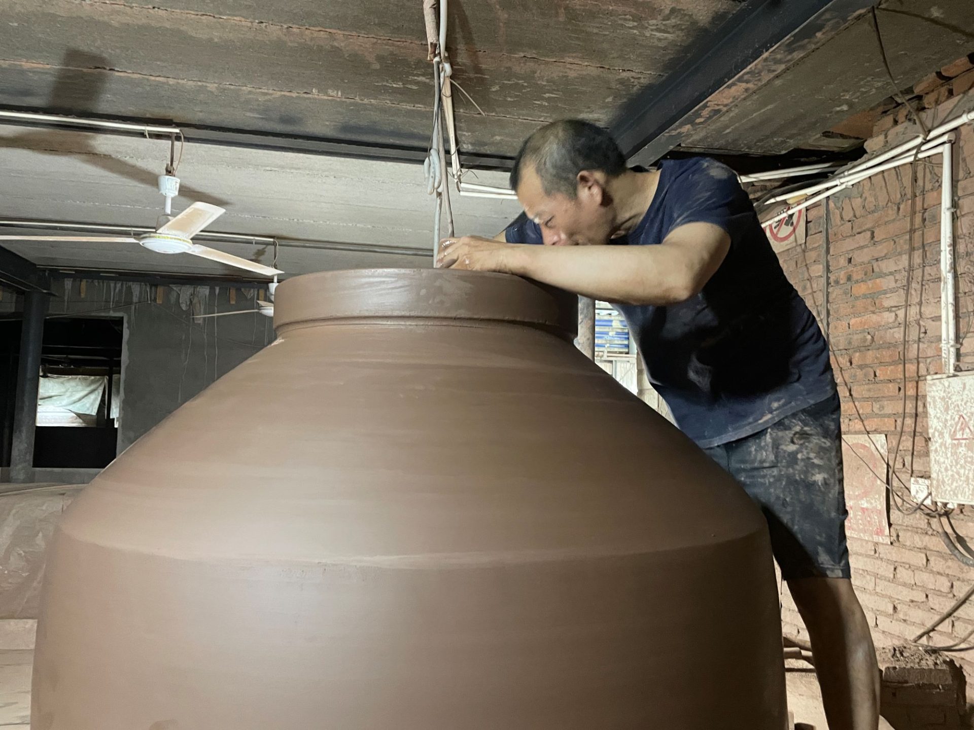 Craftsmen use manual skills to repair clay wine jars