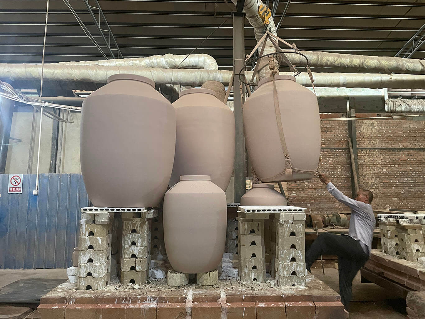 Fix the finished terracotta jars onto the refractory bricks and place it in the kiln for firing