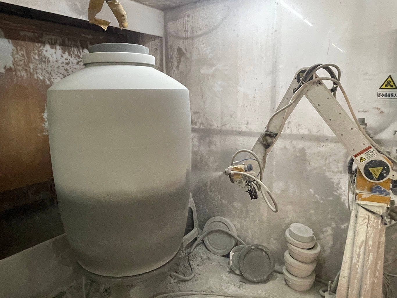 Spray glaze on terracotta jars with an automatic glaze spraying machine