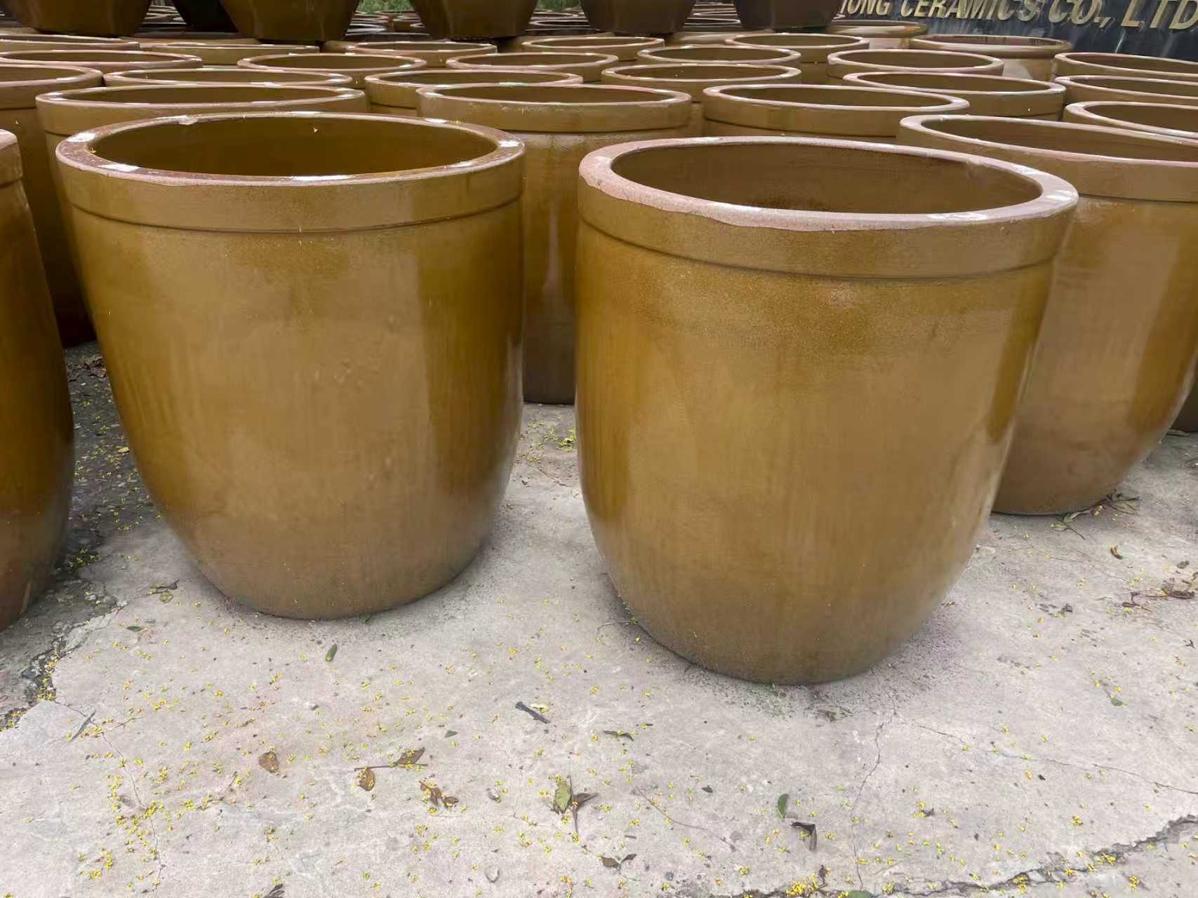 Wide mouthed large fermentation crocks displayed outdoors