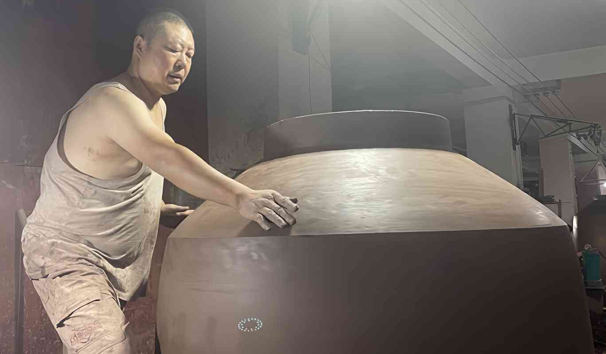 Craftsmen carefully polish the Amphora Wine Vessel