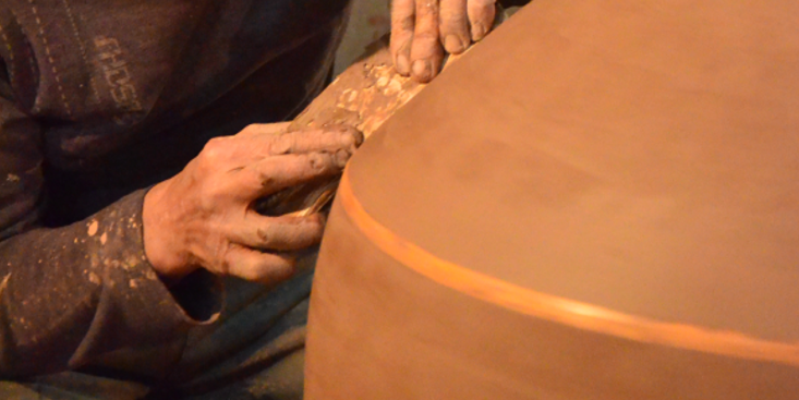 Craftsmen meticulously craft wine jar